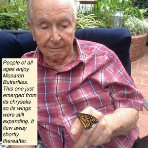 Older man with a Monarch Butterfly on his finger.